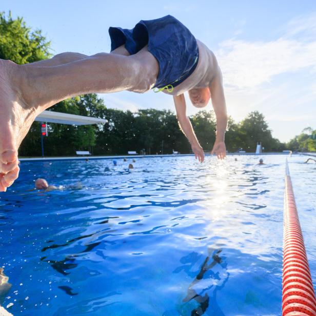 Ein Mann springt in ein Sportbecken. 