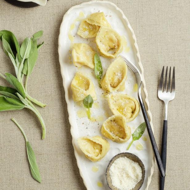 Cappellacci-Pasta auf einem Teller mit Salbei und Parmesan.