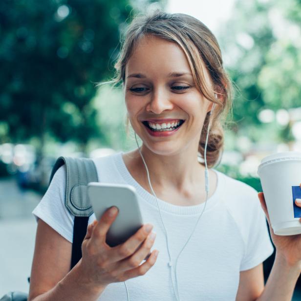 Eine Frau hört Musik am Smartphone (Symbolbild).
