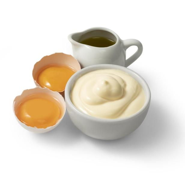 Mayonnaise in einer weißen Schale mit Eigelb und Öl.