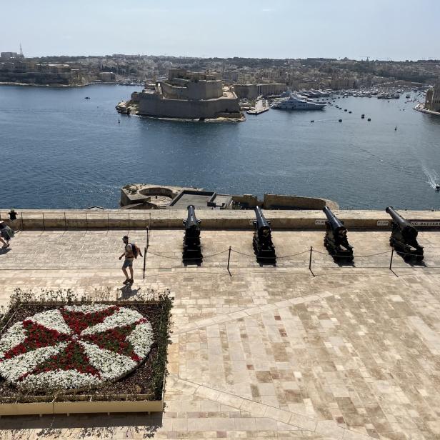 Blick über die Saluting Battery in Valletta, Malta, mit Kanonen und Blumenmuster.