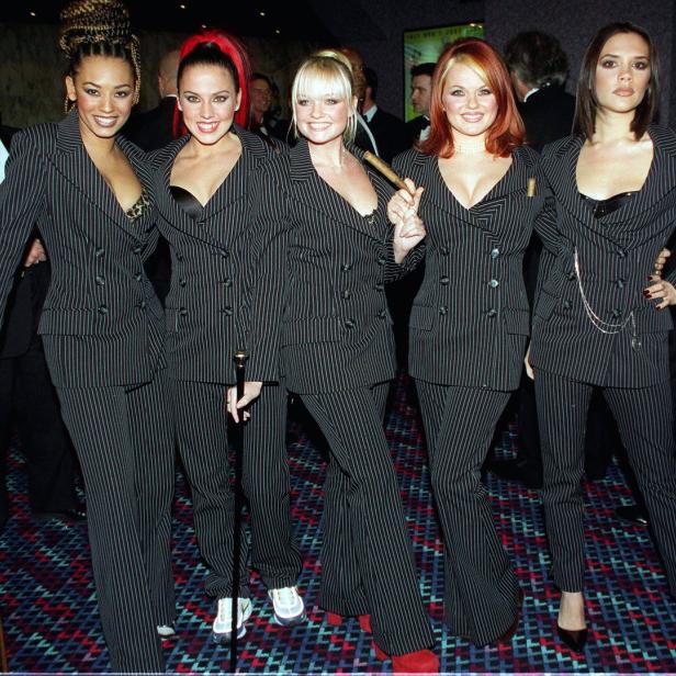 Die Spice Girls posieren in gestreiften Anzügen für ein Foto.
