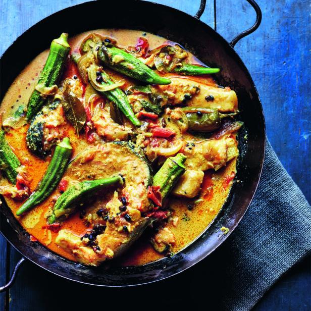 Ein Fischcurry mit Okraschoten wird in einer schwarzen Pfanne serviert.