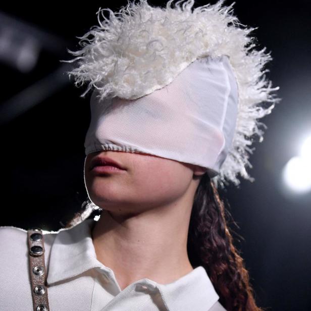 Ein Model trägt eine Kopfbedeckung, die die Augen verdeckt.