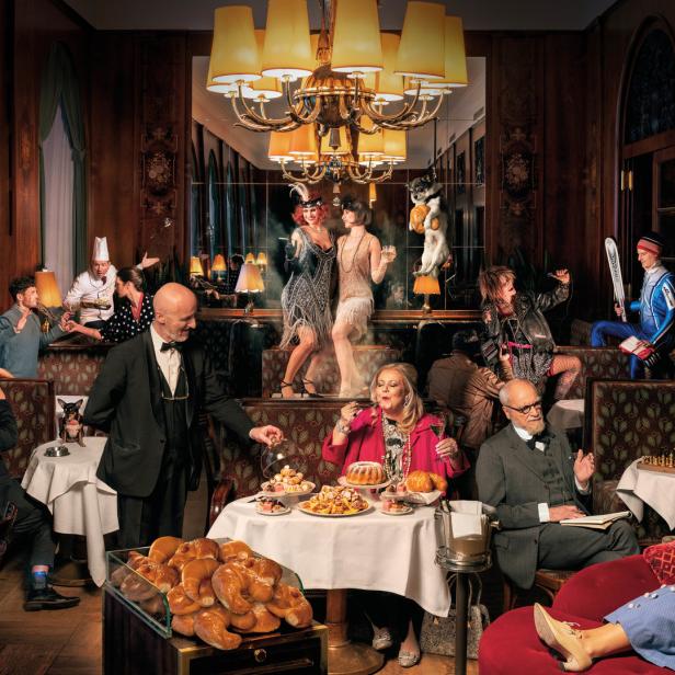 Eine lebhafte Szene in einem eleganten Restaurant mit Gästen in verschiedenen Kostümen und Posen.