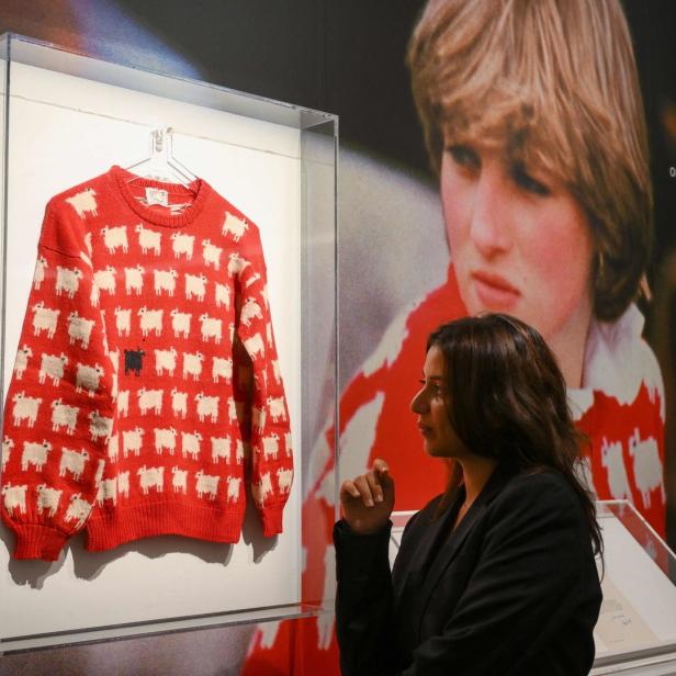 Eine Frau betrachtet Prinzessin Dianas „Black Sheep“-Pullover in einer Ausstellung.