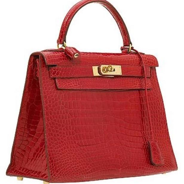 Eine rote Handtasche mit Krokodilmuster und goldenen Akzenten.
