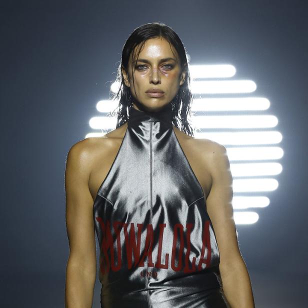 Irina Shayk trägt ein silbernes Kleid mit dem roten Schriftzug „So Wavy Lola“.