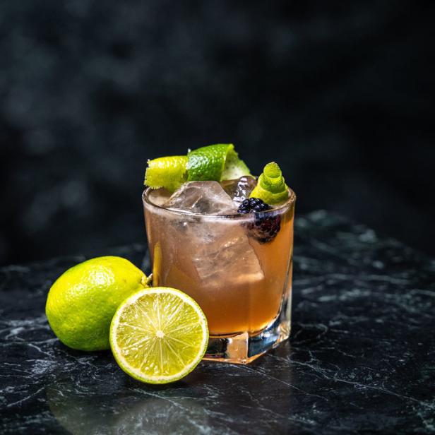 Ein Cocktail aus dem Barfly's, garniert mit Limettenzesten und Brombeeren.