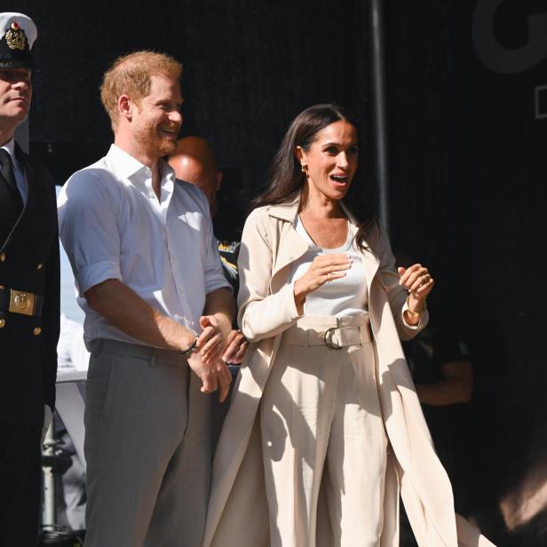 Meghan Markle und Prinz Harry stehen zusammen auf einer Bühne.