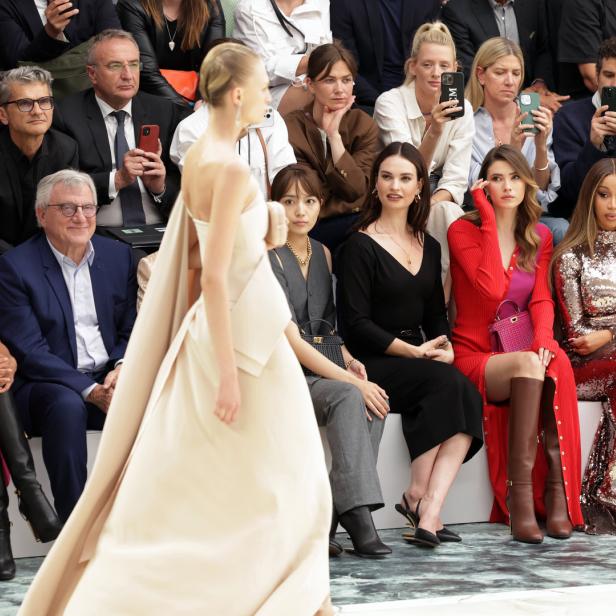 Eine Modenschau mit prominenten Gästen wie Shakira, Camila Cabello und Cardi B in der ersten Reihe.