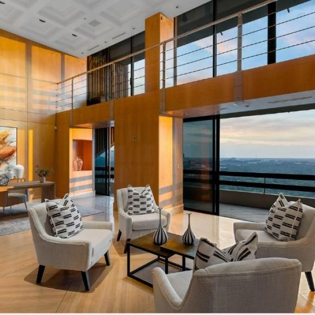 Ein luxuriöses Wohnzimmer mit Sesseln und Blick auf die Stadt.