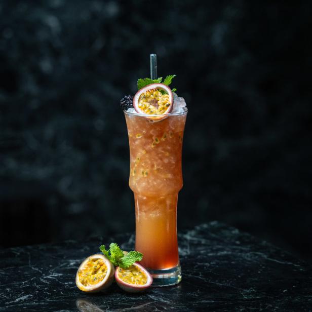 Ein „Wocka-Cocktail Sex on the Sofa“ mit Passionsfrucht und Brombeere garniert.