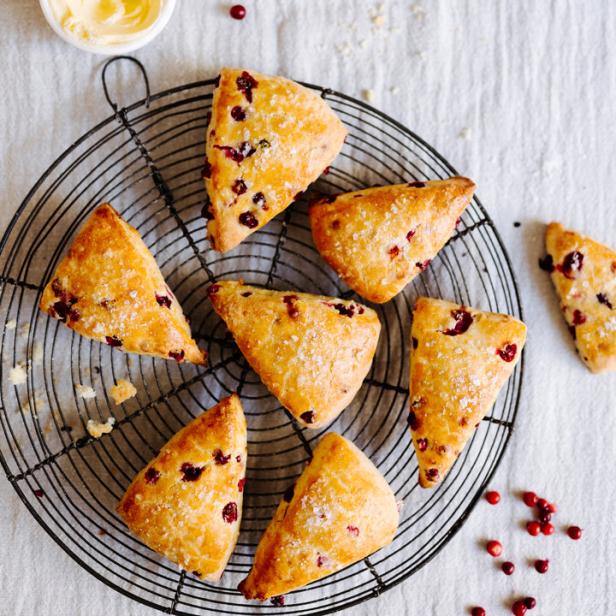 Mehrere Cranberry Scones liegen auf einem schwarzen Drahtgestell.