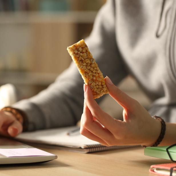 Eine Frau snackt beim Arbeiten.