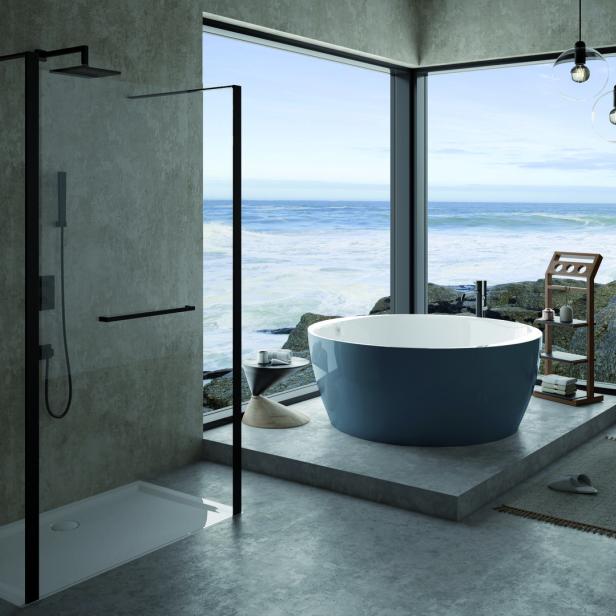Ein modernes Badezimmer mit Meerblick, einer freistehenden Badewanne und einer begehbaren Dusche.