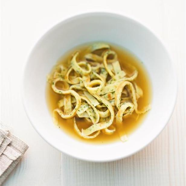 Eine Schüssel mit Frittatensuppe auf einem weißen Tisch.