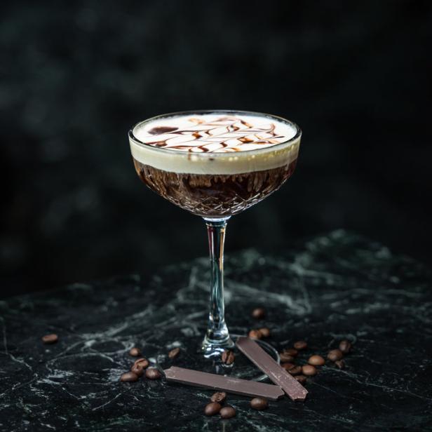 Ein Cocktail, White Russian Royal, mit Kaffeebohnen und Schokoladenstücken.