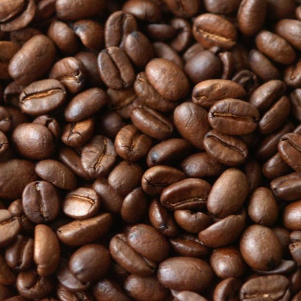Nahaufnahme von vielen gerösteten Kaffeebohnen.