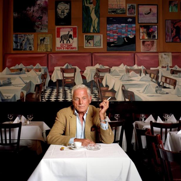 Ein Mann sitzt in einem Restaurant und raucht eine Zigarette.