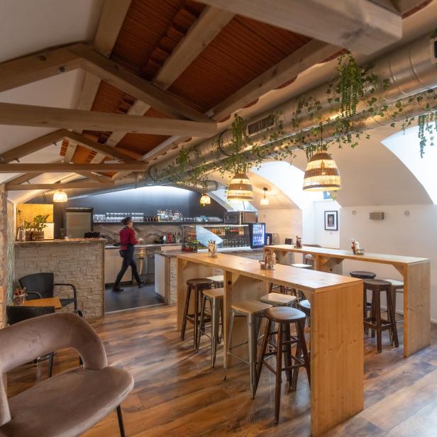 Innenansicht eines Restaurants mit Holzböden und einer Person im Hintergrund.