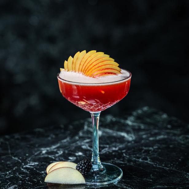 Ein „Pomme Rouge“ Apfel-Cocktail mit Apfelscheiben garniert.