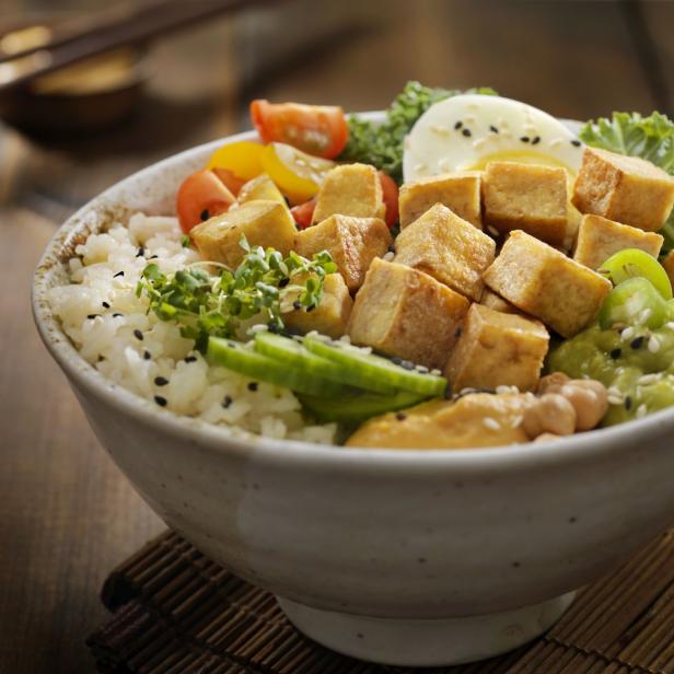 Eine Schüssel mit Tofu, Reis, Gemüse und einem halben Ei.