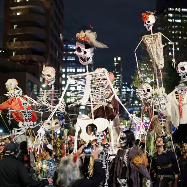 Eine Halloween-Parade zieht durch Greenwich Village in New York, mit vielen Skeletten und Zuschauern.
