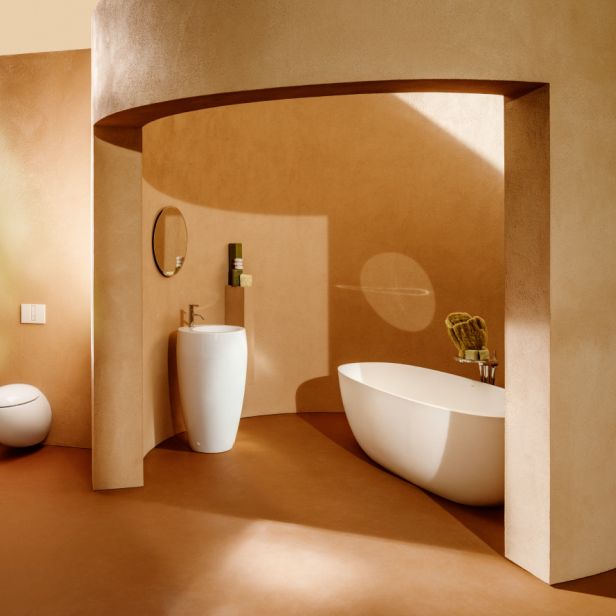Ein Badezimmer in Erdtönen mit freistehender Badewanne, Waschtisch und Toilette.