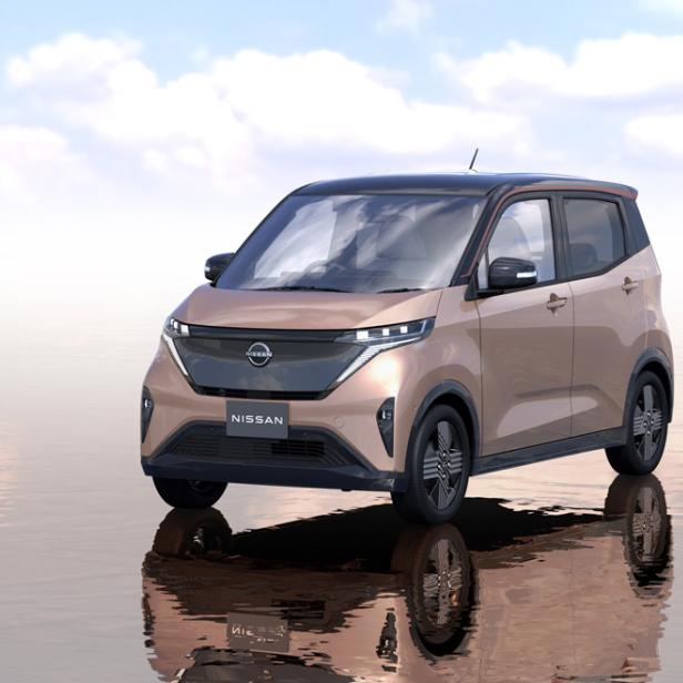 Ein rosafarbener Nissan Sakura steht auf einer reflektierenden Oberfläche.