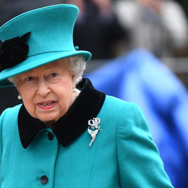 Königin Elizabeth II. trägt einen türkisfarbenen Hut und Mantel.