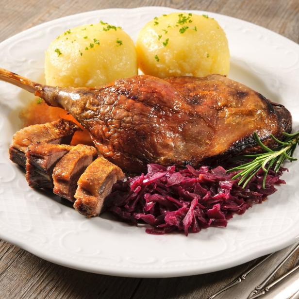 Ein Teller mit knuspriger Entenkeule, Rotkohl und Kartoffelknödeln.