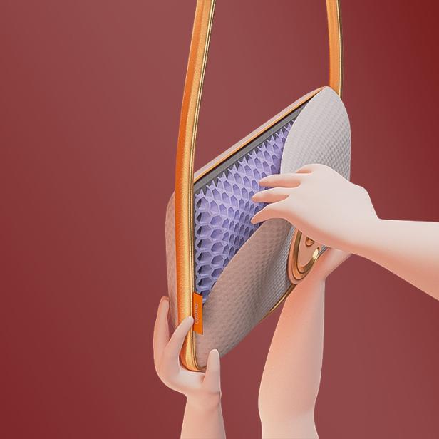 Eine Hand öffnet die „Emma The Pillow Bag“ und zeigt das Innenleben.