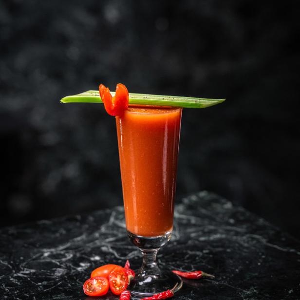 Ein Bloody Mary Cocktail mit Sellerie und Chili garniert.