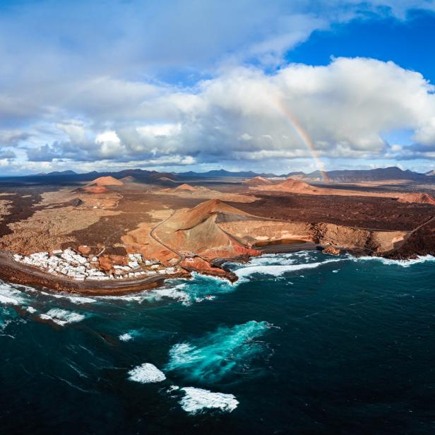 Luftaufnahme von El Golfo, Lanzarote, mit einem Regenbogen im Hintergrund.