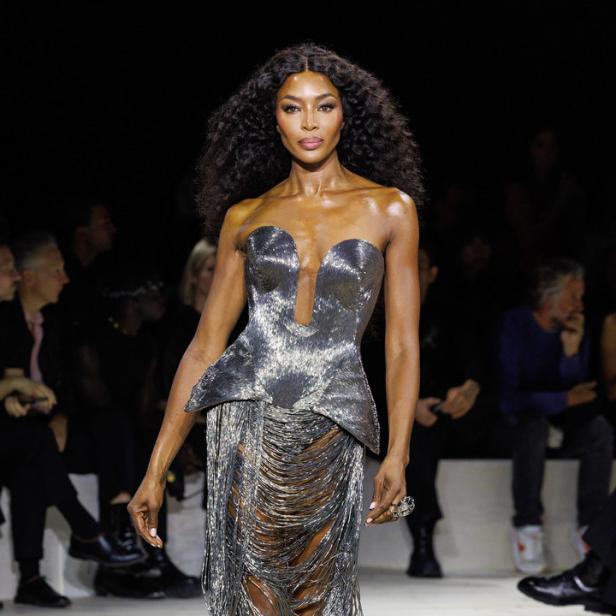 Naomi Campbell läuft in einem silbernen Kleid über den Laufsteg.