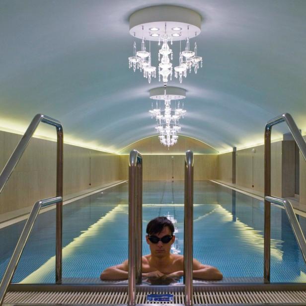 Ein Mann mit Schwimmbrille lehnt im Pool des Sans Souci.