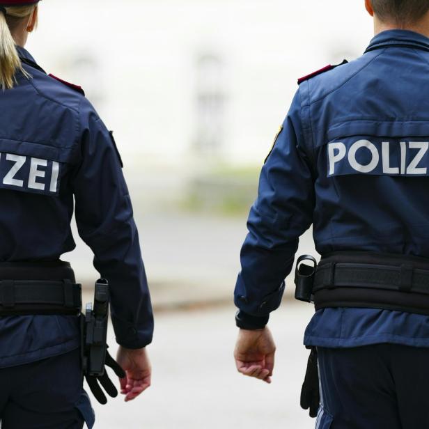 Zwei Polizisten gehen nebeneinander.