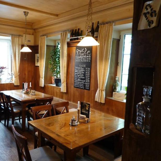 Innenansicht eines traditionellen Restaurants mit Holztäfelung und Biermenü.