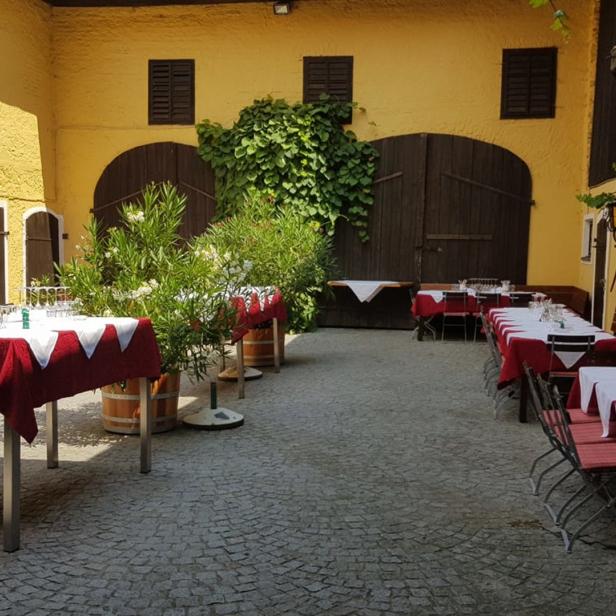 Ein Innenhof mit gelben Wänden und Tischen, die für eine Veranstaltung gedeckt sind.