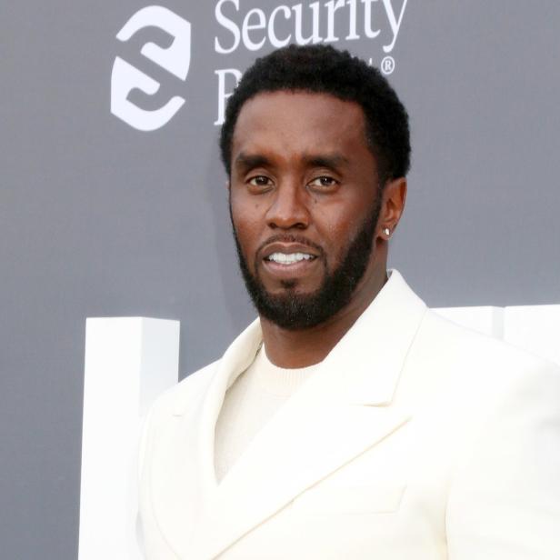 Sean „Diddy“ Combs trägt einen weißen Anzug vor einem Billboard Music Awards-Hintergrund.