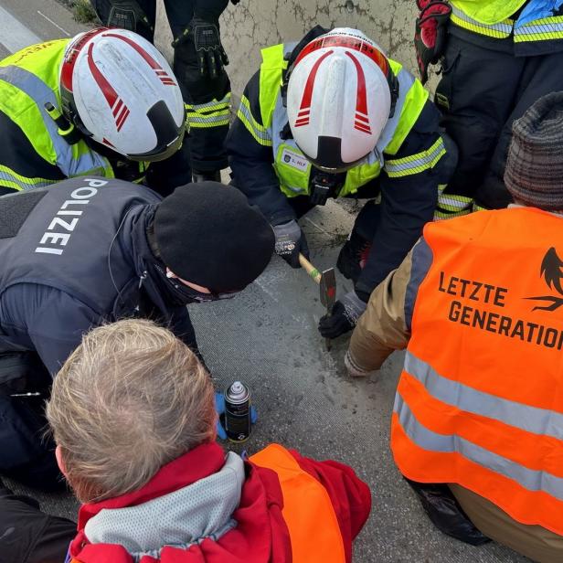Einsatzkräfte versuchen, Aktivisten der „Letzten Generation“ von der Straße zu lösen.