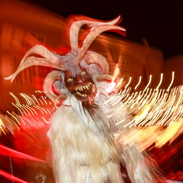 Ein Krampus mit Fell, Hörnern und einer furchteinflößenden Maske bei einem Umzug.