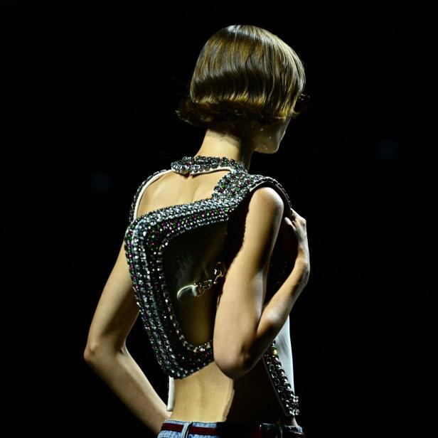 Ein Model präsentiert ein mit Strasssteinen besetztes Oberteil von Gucci Frühjahr 2024.