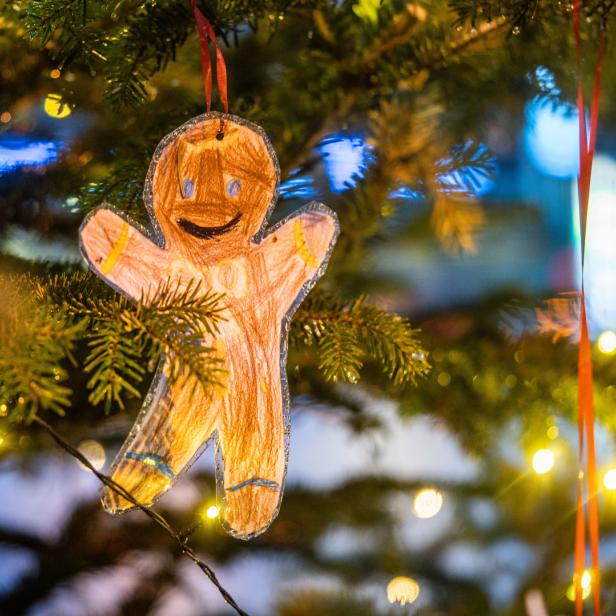 Ein selbstgemachter Lebkuchenmann hängt an einem Weihnachtsbaum.