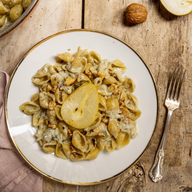 Conchiglie-Nudeln mit Birne, Gorgonzola und Walnüssen auf einem Teller.