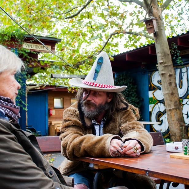 Ein Mann und eine Frau sitzen im Freien an Tisch
