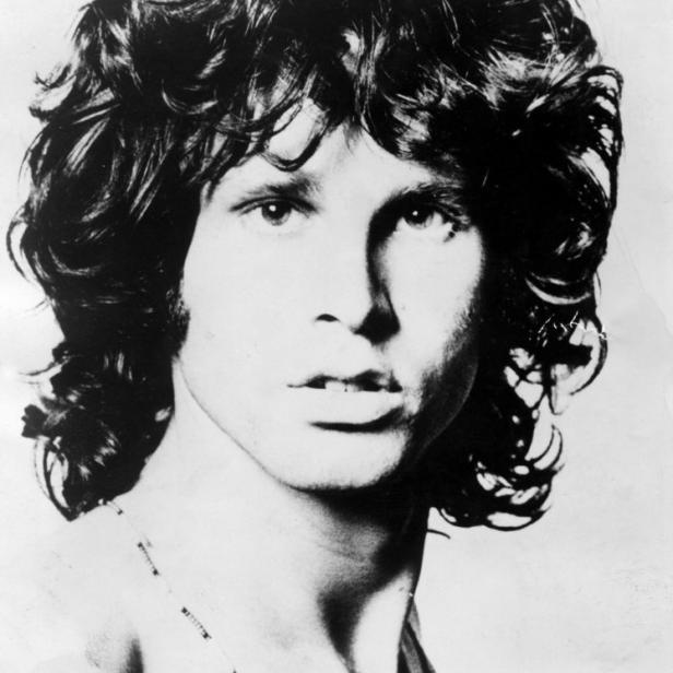 Ein Schwarz-Weiß-Porträt von Jim Morrison mit lockigem Haar und einer Halskette.
