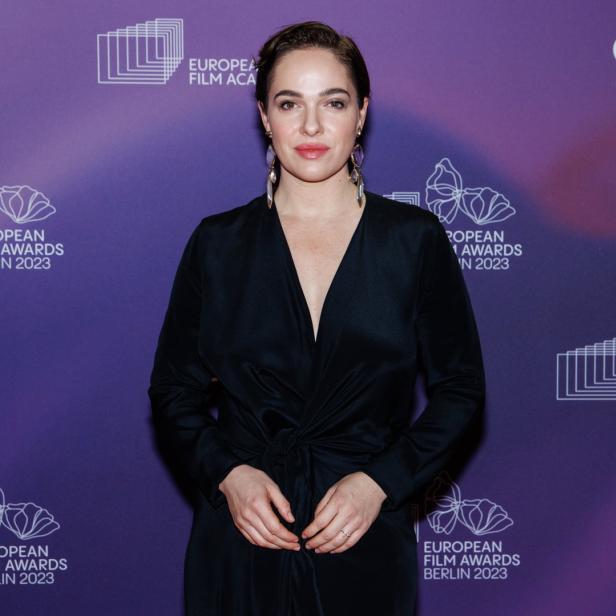 Die Schauspielerin Aylin Tezel posiert vor einem lila Hintergrund der European Film Awards.