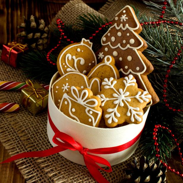 Lebkuchen in einer weißen Schachtel mit rotem Band auf einem Holztisch.